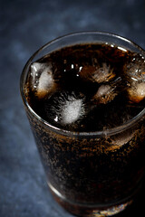 glass of coca cola with ice on a dark background, top view vertical