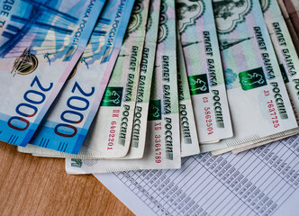 On top of  financial document is based on  Russian banknotes. 2000 and 1000 rubles. Payment of bills. Family budget.