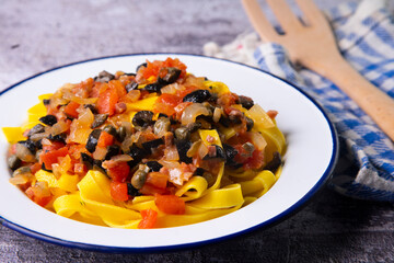 Traditional pasta with black olives and tomato