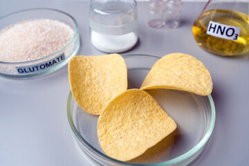 Potato chips in lab. Food safety laboratory procedure, analysing potato chips from the market. Workplace lab assistant. Close up.