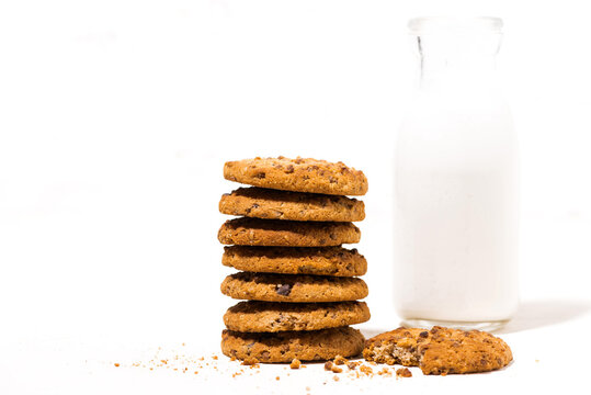 oatmeal cookies with chocolate chips on a white background and a bottle of milk - Powered by Adobe
