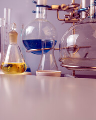 Flasks, test tubes and laboratory glassware with solutions of different colors on the table in the laboratory.
