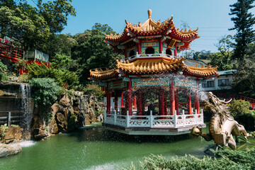 Fototapeta premium Golden dragon water fountain with pond and buddhist gazebo in Taipei Taiwan