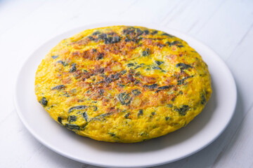 Spanish potato omelette with spinach. Traditional tapa.