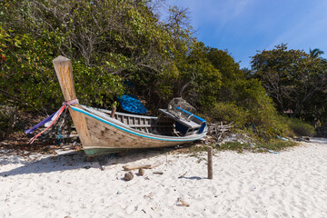 A broken boat stands on the sand. Boat by the sea. Fishing boat washed ashore.