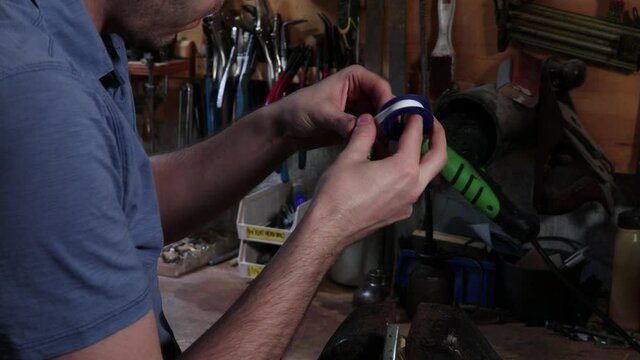 Handyman Repairs Machine Part with Plumbers Tape
