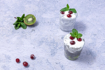 healthy breakfast - chia seeds, yogurt, kiwi and frozen cherries on a blue background