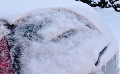 Zaśnieżony i oblodzony samochód w czasie zimy.