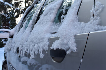 Zaśnieżony i oblodzony samochód w czasie zimy. - obrazy, fototapety, plakaty
