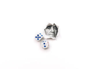 Franklin portrait in a torn hole of white paper and two dice. The concept of gambling, casino, losing and luck. Win or lose. Copy space.