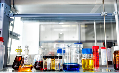 Closeup of laboratory glassware filled with various colored liquids, science and research background, selective focus