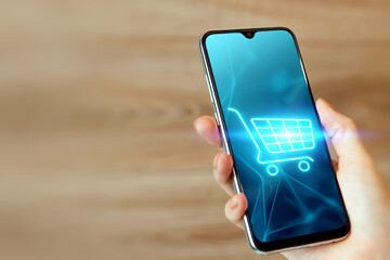 Phone and basket hologram. Online shopping, online store application in a smartphone. Digital Marketing Online.