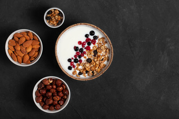 Homemade granola breakfast bowl with natural yogurt, berries, hazelnut and almond. Copy space.