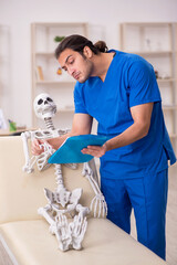 Young male doctor and skeleton patient in the clinic