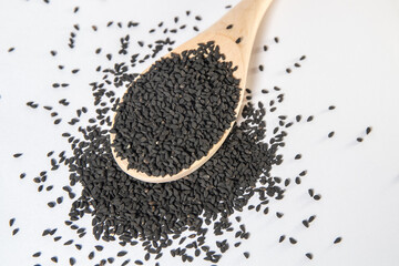 dried Nigella sativa seeds on a wooden spoon