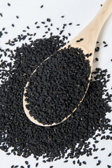 dried Nigella sativa seeds on a wooden spoon