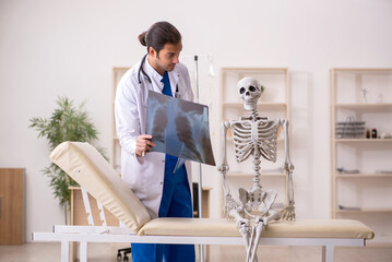 Young male doctor radiologist and skeleton patient in the clinic