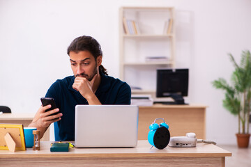 Young male employee working at workplace