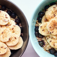 Healthy breakfast. Top view. Oatmeal with banana and flax seeds at bowl. Berry in plate. Organic meal recipe. Vegan cook. Minimalism granola. Hot porrigde with fruit. Closeup