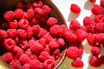 Red ripe and juicy raspberry in an inverted small bowl