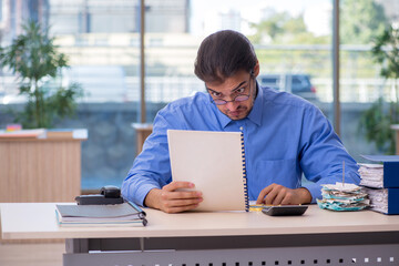 Fototapeta premium Young male bookkeeper in budget planning concept