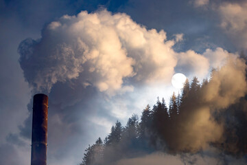 Double exposure of chimney smoke and forest.