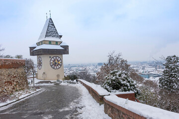 The famous clock tower on Schlossberg hill, in Graz, Styria region, Austria, with snow, in winter