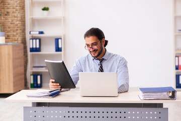 Fototapeta premium Young male employee working in the office