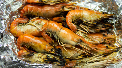 Grilled Shrimp with Seafood Sauce Contained in aluminum foil food wrap and foam food container. Thai style seafood sauce, spicy and sour taste, main ingredient, lime juice, fresh chili, fish sauce