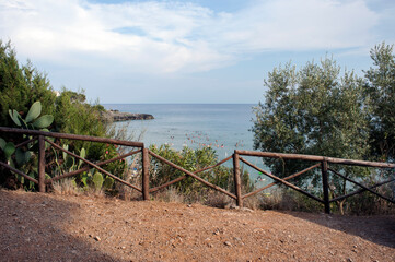 Path along the coast with an inlet and beaches below.  Calanca cove in Marina di Camerota, Salerno, Italy.