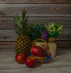 Mango fruit in a basket, in a vintage still life. Ripe apples and pineapple fruit