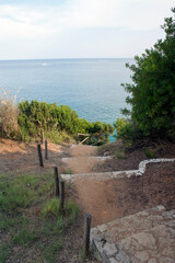 Path with some steps and old picket fence to go down on a beach. Marina di Camerota, Salerno, Italy.