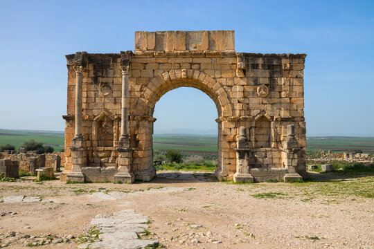 Arch of Caracalla (Triumphal Arch) at the Archaeological Site of Volubilis under a blue sky, Fes-Meknes, Morocco.