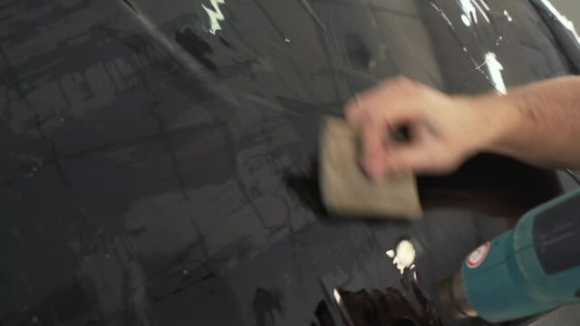 Car window tinting. Process of Installation window tint in Car Detailing Studio Garage by professional detailer.