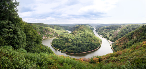 wide panorama of famous saarschleife river-bend in saarland germany, top view of spectecular tourist viewpoint - obrazy, fototapety, plakaty