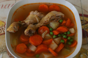 Hungarian chicken soup with vegetables and paprika in a white plate
