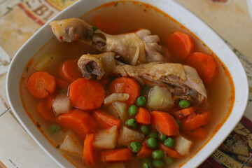 Hungarian chicken soup with vegetables and paprika in a white plate
