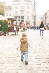 Fototapeta na wymiar a little boy walking alone in the old town