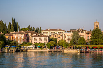 The pier and promenade of Sirmione on Lake Garda. Autumn evening. Lombardy, Italy