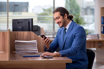 Fototapeta na wymiar Young male employee unhappy with excessive work in the office