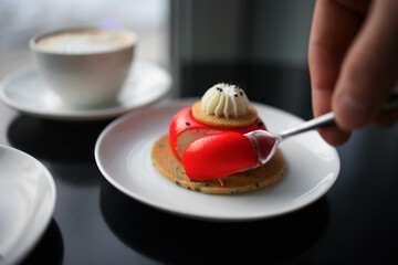 red strawberry cheesecake stuffed with cappuccino on a black table