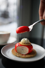 red strawberry cheesecake stuffed with cappuccino on a black table