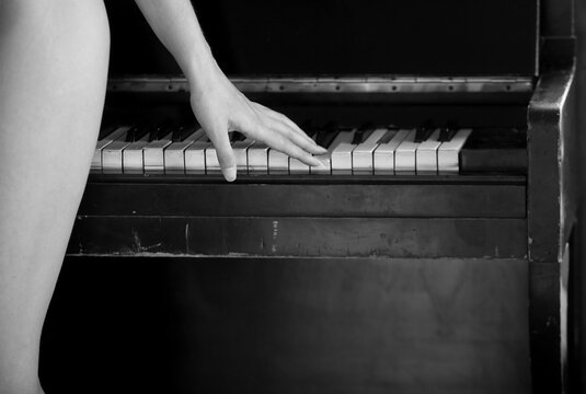 A young attractive girl plays the piano, a naked figure Stock Photo | Adobe  Stock