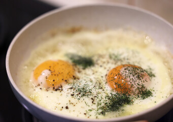 Frying pan with fried egg sprinkled with dill