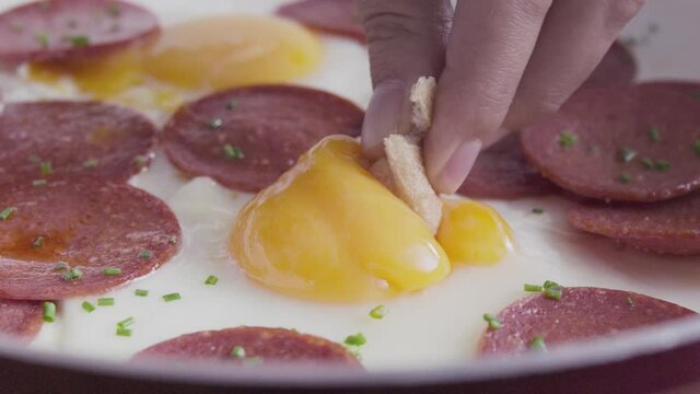 A man eating breakfast eats Turkish sausage with bread. Turkish sucuk. Slow and close up.