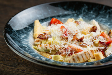 Caesar salad with grilled chicken breast. Greek salad with fresh vegetables, croutons, cherry tomatoes, fried bacon, quail eggs and grated cheese