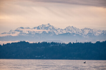 Snow-capped mountains with forests in front on a cloudy day