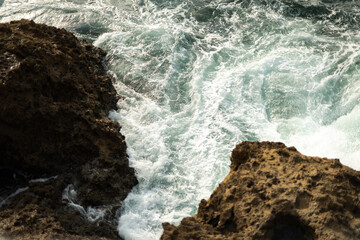Waves breaking against the rocks of the shore.