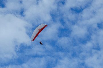 Flying on a paraglider. Paraglider with two passengers on a background of blue sky