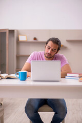 Young male student preparing for exams at home